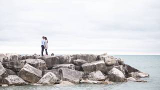 young couple kissing on a rock jetty