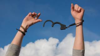 man breaking free of hand cuffs, addiction