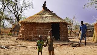 african village huts and family