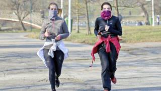 women running in a park, with masks and separate, no others around them