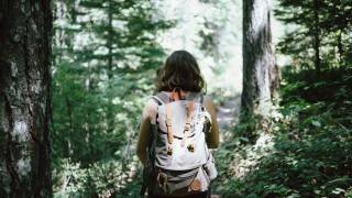 young girl in woods hiking