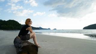woman sitting on rock near sea