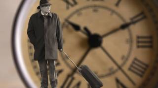 man standing by a clock
