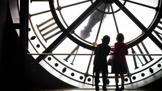 women in front of a big clock