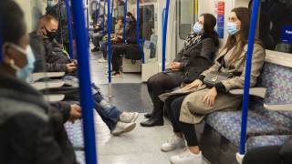 passengers with masks on shuttle to the airport