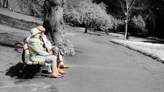 older couple sitting on a park bench