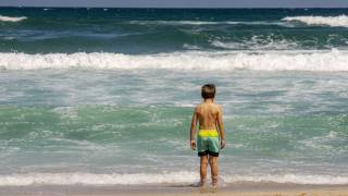 young boy looking at the ocean surf