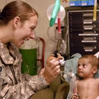 army doc helping a little toddler