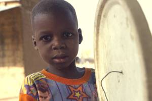 young nigerian boy holding a drum