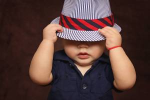 young toddler boy with hat over his eyes