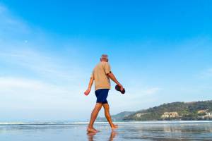 older man walking on a sunny beach