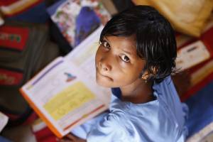 young indian girl studying, looking up at the camera