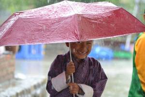 cute little boy holding umbrella in the rain