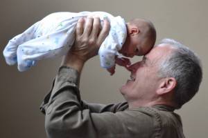 grandpa with his new grand baby protected from pertussis