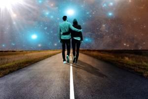 couple walking along a road in the starry night